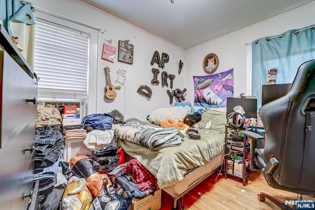 bedroom with hardwood / wood-style floors and cooling unit