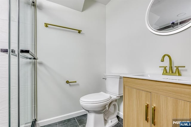 bathroom featuring vanity, a shower with door, tile patterned floors, and toilet