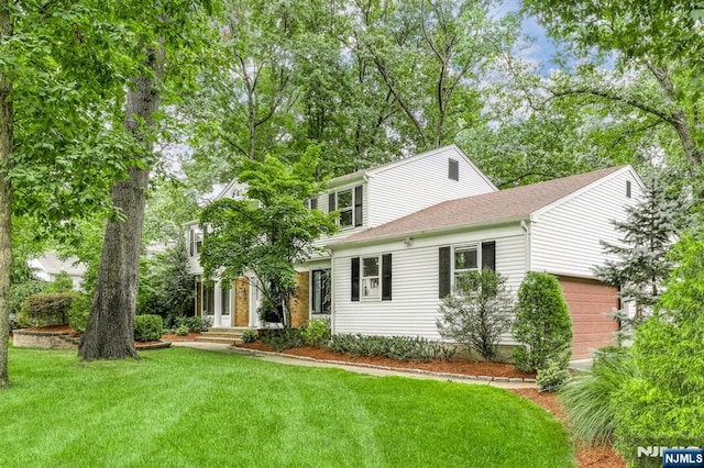 view of front of home with a garage and a front lawn