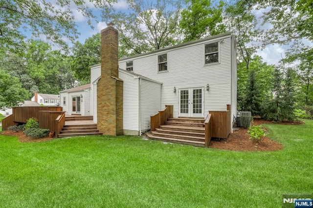 rear view of house with french doors, a yard, a wooden deck, and central AC unit