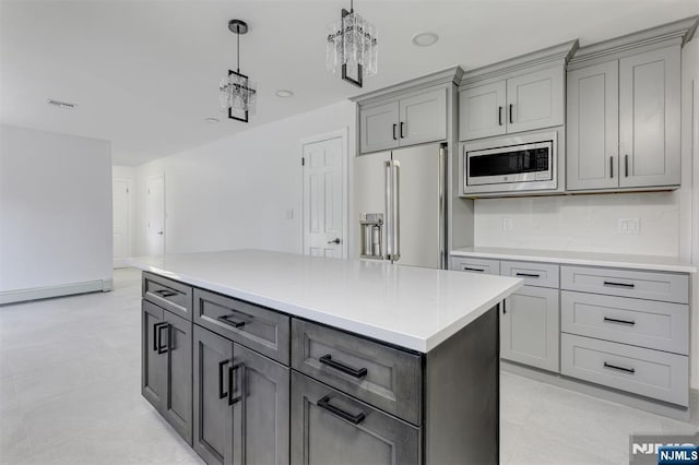 kitchen with light tile patterned floors, gray cabinets, stainless steel appliances, a kitchen island, and decorative light fixtures