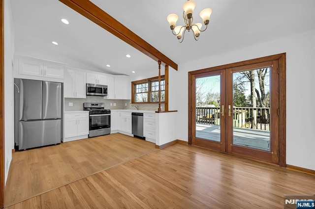 kitchen featuring appliances with stainless steel finishes, backsplash, vaulted ceiling with beams, white cabinets, and light wood-type flooring