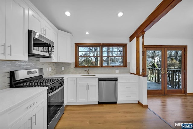 kitchen with white cabinetry, appliances with stainless steel finishes, sink, and tasteful backsplash