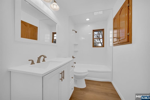 full bathroom with vanity, wood-type flooring, washtub / shower combination, and toilet