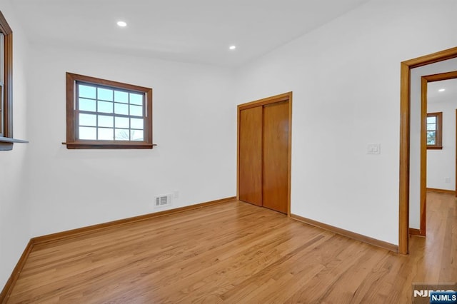 spare room featuring a wealth of natural light and light wood-type flooring