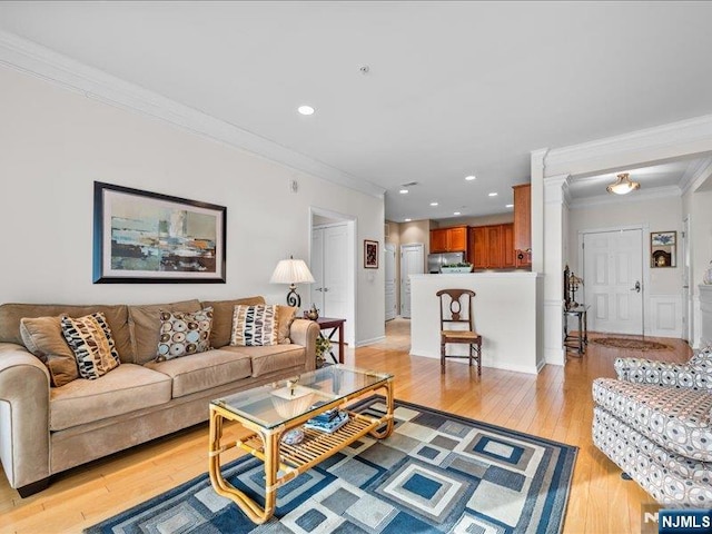 living room with crown molding and light hardwood / wood-style flooring