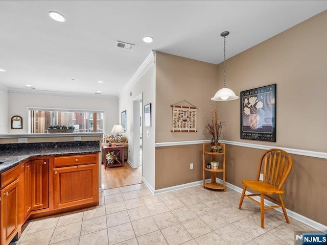 kitchen featuring ornamental molding, decorative light fixtures, light tile patterned floors, and dark stone countertops