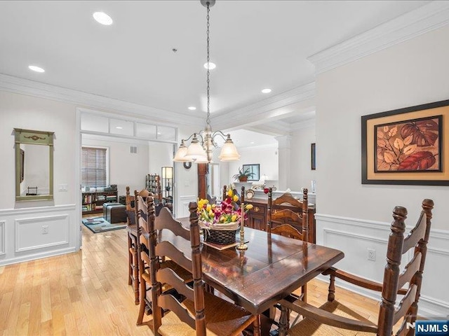 dining space with ornamental molding, light hardwood / wood-style floors, and ornate columns