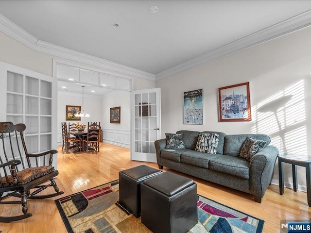 living room with ornamental molding, wood-type flooring, and french doors