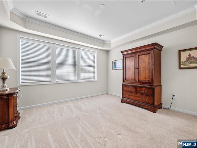 carpeted bedroom featuring ornamental molding and a tray ceiling