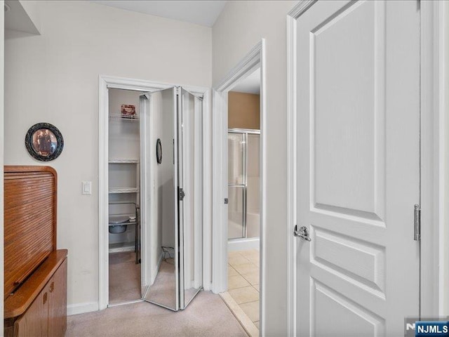 hallway featuring light colored carpet