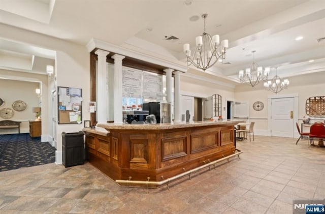 welcome area featuring an inviting chandelier and decorative columns