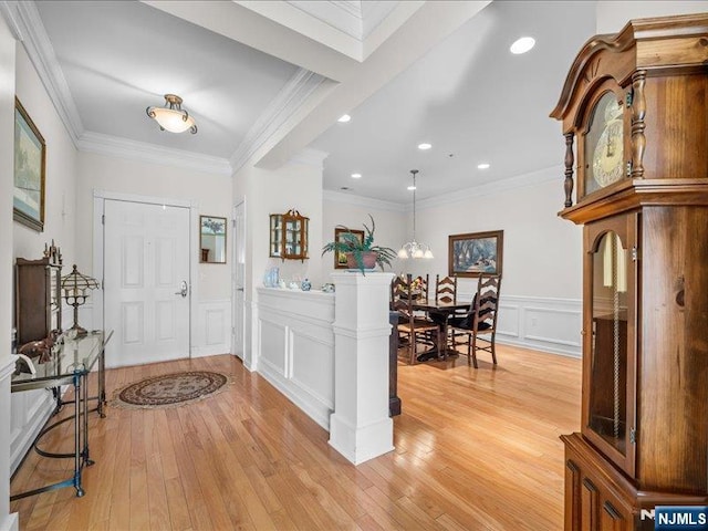 foyer entrance featuring ornamental molding and light hardwood / wood-style floors