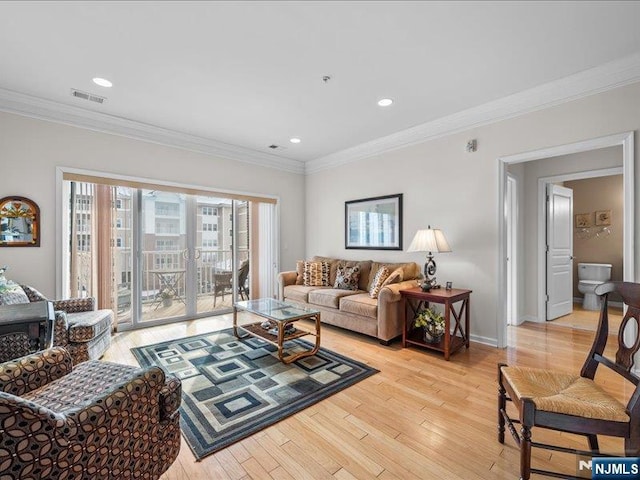 living room featuring ornamental molding and light hardwood / wood-style flooring