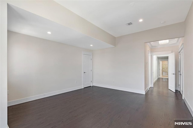 empty room featuring dark hardwood / wood-style flooring and crown molding