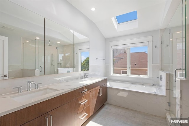 bathroom featuring vanity, lofted ceiling with skylight, and independent shower and bath