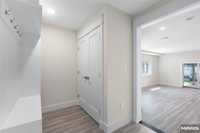 corridor with light hardwood / wood-style floors