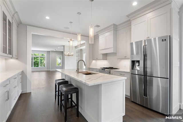 kitchen featuring stainless steel appliances, white cabinetry, sink, and an island with sink