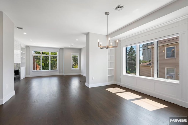 interior space with dark hardwood / wood-style flooring, a notable chandelier, and built in shelves