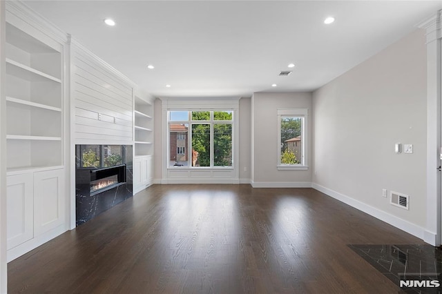 unfurnished living room with built in shelves, a fireplace, and dark hardwood / wood-style flooring