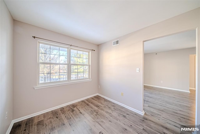 empty room with light hardwood / wood-style flooring