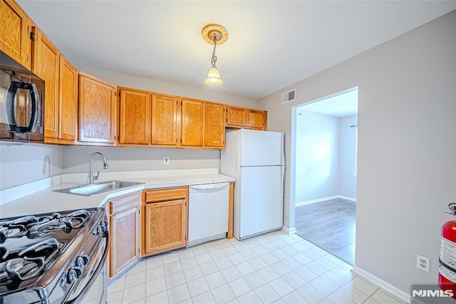 kitchen with sink, white appliances, and decorative light fixtures