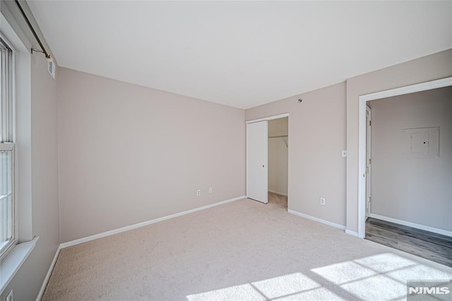 unfurnished bedroom with light carpet and a closet