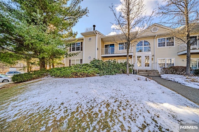 view of snow covered back of property