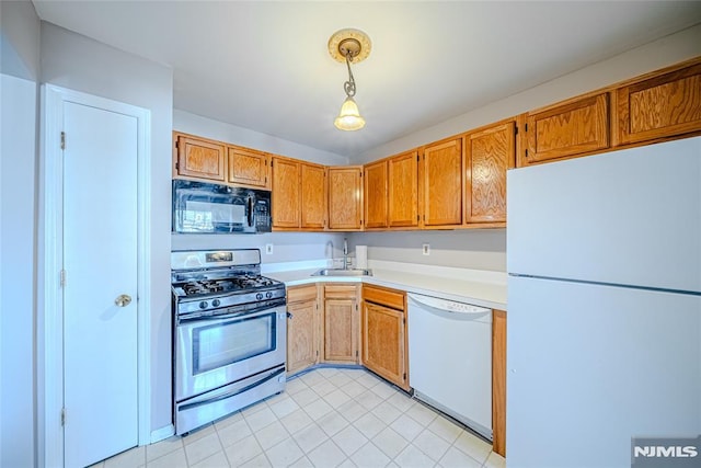 kitchen with sink, white appliances, decorative light fixtures, and light tile patterned floors