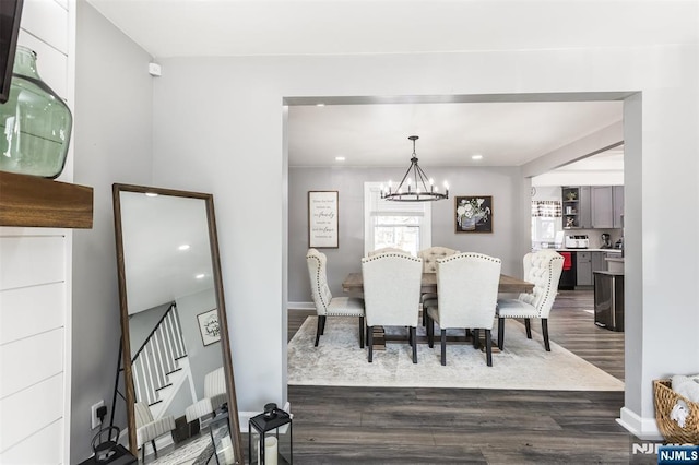 dining room with dark wood-type flooring and a notable chandelier