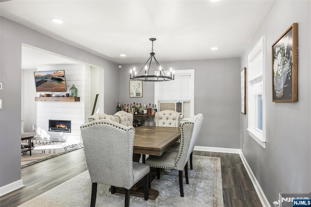 dining space featuring dark wood-type flooring and an inviting chandelier