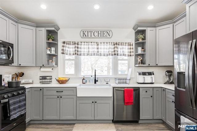 kitchen featuring gray cabinetry, sink, hardwood / wood-style flooring, and stainless steel appliances