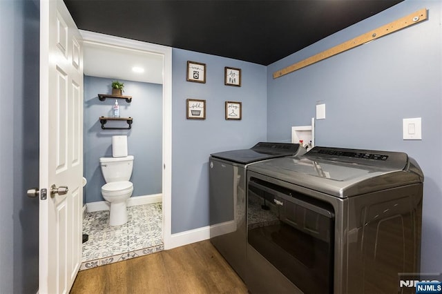 laundry room featuring separate washer and dryer and hardwood / wood-style floors