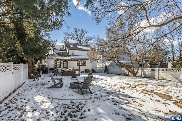 snow covered house with an outdoor living space with a fire pit