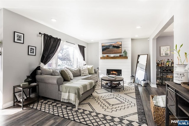 living room with dark hardwood / wood-style flooring and a fireplace