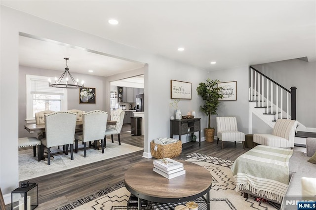 living room featuring wood-type flooring and an inviting chandelier