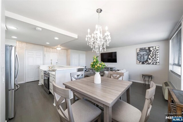 dining space with dark hardwood / wood-style floors and a notable chandelier