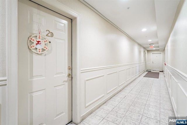 hallway featuring a wainscoted wall, recessed lighting, and a decorative wall