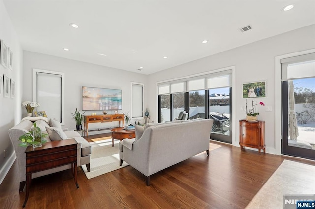 living room featuring a wealth of natural light and dark hardwood / wood-style flooring