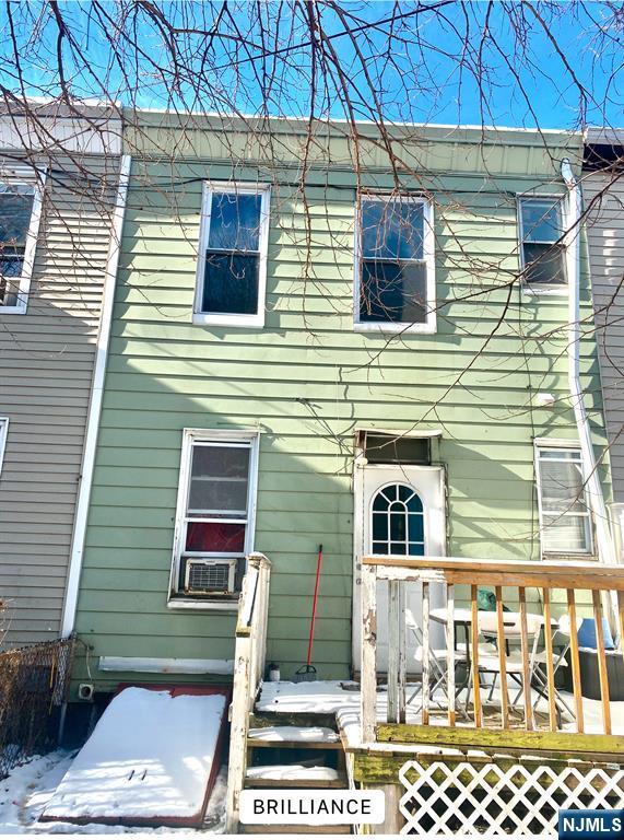 back of house featuring cooling unit and a deck