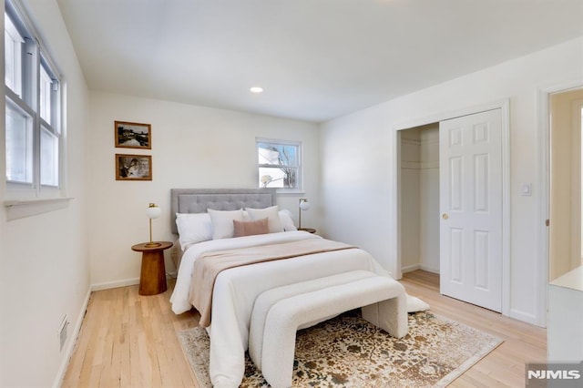 bedroom with light wood-type flooring and a closet