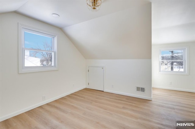 bonus room with light hardwood / wood-style flooring, a healthy amount of sunlight, and vaulted ceiling