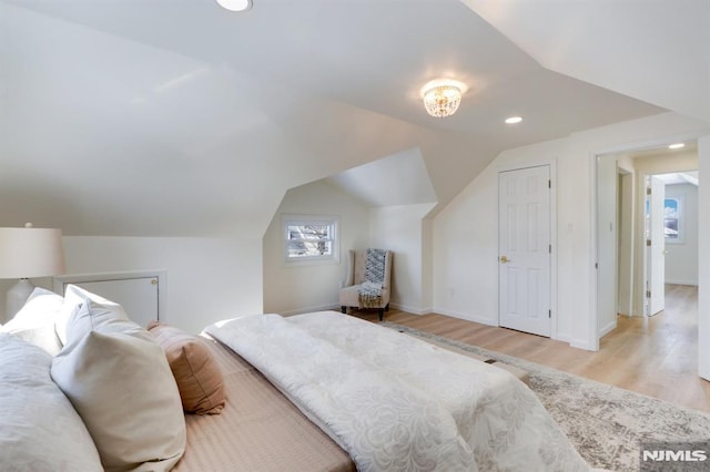 bedroom featuring lofted ceiling and light hardwood / wood-style flooring