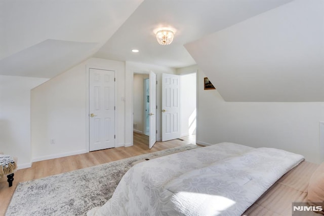 bedroom with light hardwood / wood-style flooring and vaulted ceiling