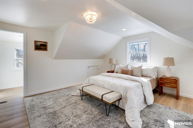 bedroom with vaulted ceiling and light hardwood / wood-style flooring