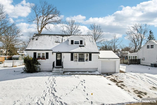 cape cod-style house with central AC and a garage