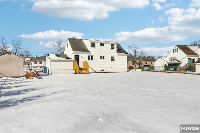 view of snow covered rear of property