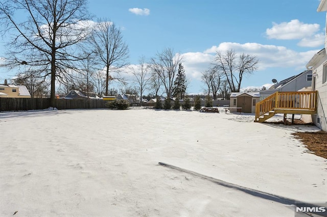 yard covered in snow with a storage unit