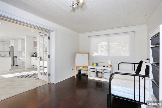 bedroom featuring dark wood-type flooring, multiple windows, and stainless steel refrigerator