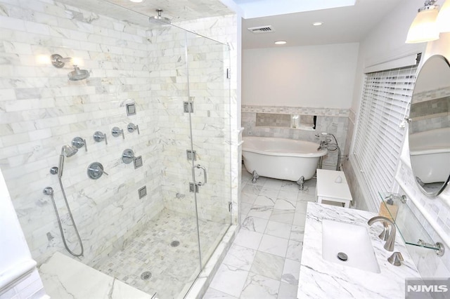 bathroom featuring vanity, separate shower and tub, and tile walls